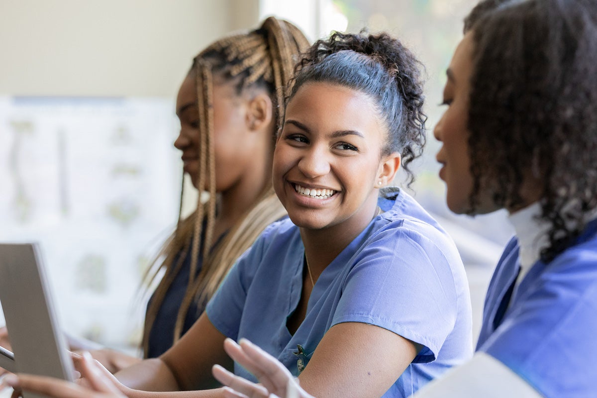 Three nurses talking to one another, happily